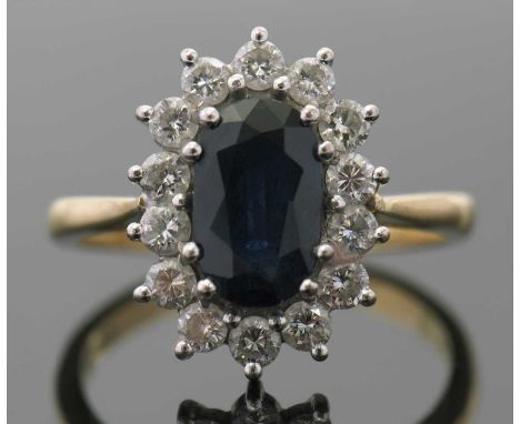An 18ct sapphire and diamond ring, the oval sapphire surrounded by round brilliant cut diamonds, total estimated approx. 0.70