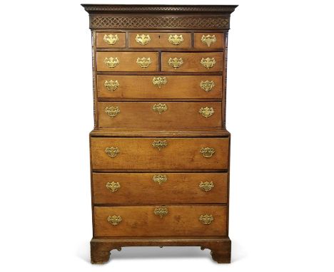 A George III Oak Chest on Chest the top section with moulded and dentil cornice, blind fretwork detail, an unusual configurat