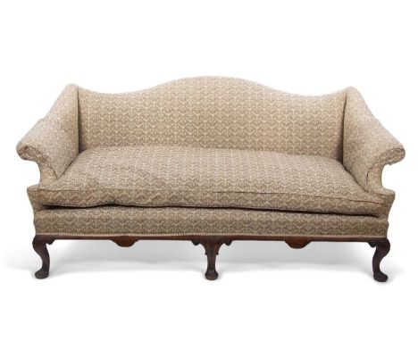 A camel backed sofa upholstered in beige floral fabric and raised on short cabriole legs with carved knees and pad feet, 170c