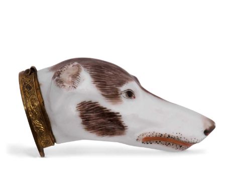 A late 19th Century continental porcelain and gilt metal snuff box, realistically modelled as a dog's head, the hinged cover 
