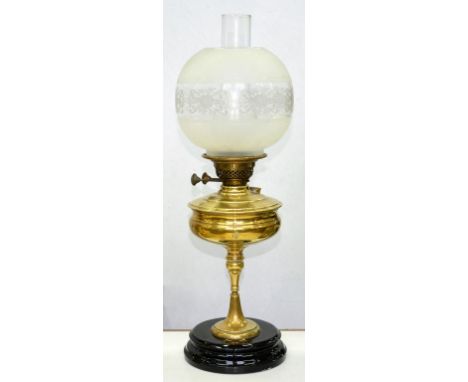 AN EDWARD VII BRASS OIL LAMP ON BLACK GLAZED POTTERY FOOT, WITH ETCHED GLASS GLOBE, 54CM H EXCLUDING CHIMNEY 