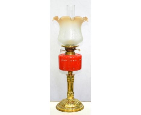 AN EDWARD VII EMBOSSED BRASS OIL LAMP WITH ENAMELLED RED GLASS FOUNT AND BRASS BURNER, ETCHED GLASS SHADE, 57CM H 
