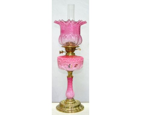 A VICTORIAN BRASS OIL LAMP, WITH MOULDED AND SHADED PINK GLASS PILLAR AND ENAMELLED FOUNT, BRASS BURNER AND LATER SHADED CRAN