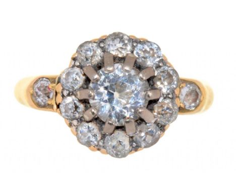A DIAMOND CLUSTER RING IN GOLD, MARKED 18C, 3.8G, SIZE K++BUILD U OF DIRT AND GRIME TO SETTINGS 