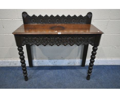 A LATE 29TH/EARLY 20TH CENTURY OAK SIDE TABLE, with raised back and single frieze drawer, both carved with wheel decoration, 