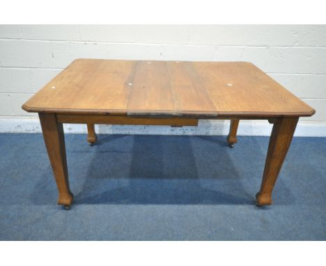 AN ARTS AND CRAFTS OAK WIND OUT DINING TABLE, with two additional leaves and one winding handle, on square tapered legs and c