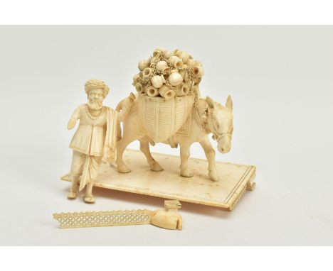 A LATE 19TH CENTURY CARVED INDIAN IVORY FIGURE GROUP, of a man following a mule who is laden with panniers of urns, on a rect