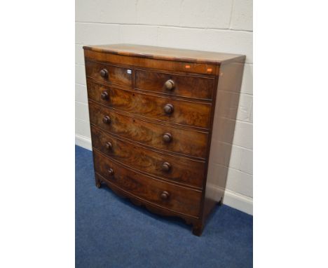 A GEORGE III FLAME MAHOGANY BOWFRONT CHEST OF TWO OVER FOUR LONG GRADUATING DRAWERS, the top with a walnut banded edging, abo