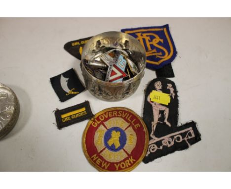 A WHITE METAL BOX CONTAINING PIN BADGES, MEDALS ETC & A BAG OF VINTAGE CLOTHING PATCHES