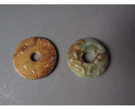 A Chinese carved jade Pi disc with dragon and phoenix, 2" dia, a similar Pi disc with flowers and scrolls, 2 1/8" dia, and an