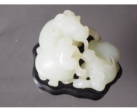 A Chinese carved jade model of two rams, on a fitted stand, 2 1/2" wide