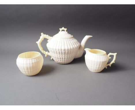 A Belleek cream and yellow glazed limpet three-piece teaset, comprising teapot, cream/milk jug and sugar bowl, and a&nbsp;Nor