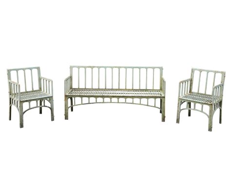 A 20TH CENTURY PAINTED CAST-IRON GARDEN SET comprising a bench and two chairs, each with a slatted design, arched aprons, and