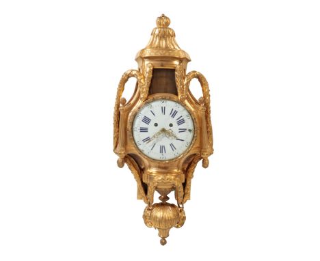 A LOUIS XVI STYLE GILT METAL WALL CLOCK, decorated with an urn finial and floral swags, the white enamel dial with blue roman