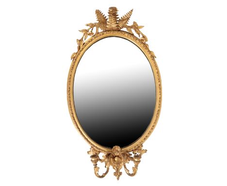 A CARVED AND GILTWOOD WALL MIRROR with a foliate cresting and girandole beneath, 91cm high