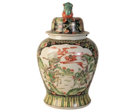 A CHINESE FAMILLE NOIRE LIDDED VASE of baluster form, with a lion dog finial, the central body decorated with martial scenes,