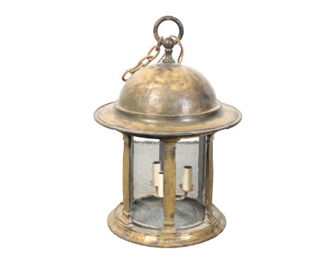 A BRASS HALL LANTERN the domed top above a glazed surround, with classical column divides, and a three branch candelabra insi