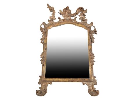 A LOUIS XV CARVED AND GILTWOOD FRAMED WALL MIRROR, circa 1760, with openwork foliate carved cresting above the shallow arched