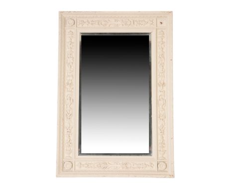 A CARVED AND CREAM PAINTED WOOD FRAMED WALL MIRROR, IN NEOCLASSICAL STYLE, of rectangular form, the sides of the surround wit