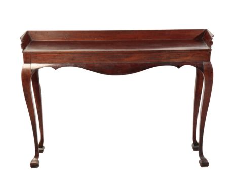 A MAHOGANY CONSOLE TABLE IN GEORGE II STYLE, the top with canted three quarter gallery above an apron to the front, on slende