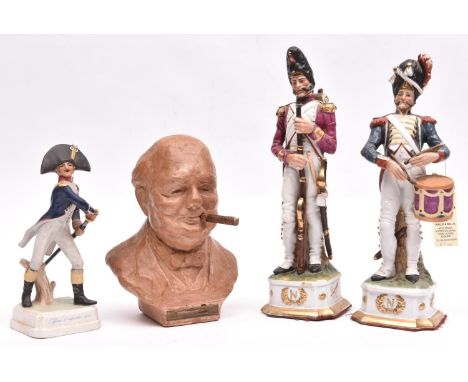 A pair of glazed porcelain figures of Napoleonic French soldiers, comprising a drummer and an infantry officer, the bases mar