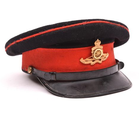 A Royal Artillery officer’s post 1902 blue peaked cap, with gilt (VGC) cap badge, regimental buttons and red trim. GC (slight