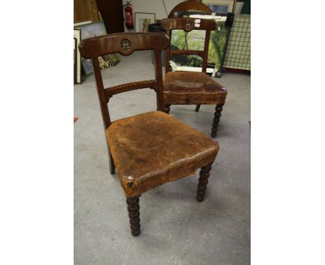 Set of six Victorian oak dining chairs in the Pugin manner, the crest rails each inset with a cast metal 'H', brown hide seat
