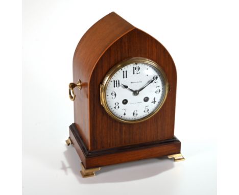 A late 19th Century Lancet shaped mantle clock in mahogany case supported on brass bracket feet and sporting brass axe-head d