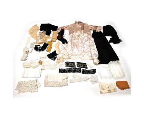 A quantity of 19th century and later textiles including a pink blouse with chain stitching, a cream shirt, a long black skirt