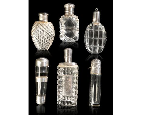 A GROUP OF SIX SCENT BOTTLES comprising: an ovoid wrythen moulded clear glass scent bottle with a cork lined plated screw top