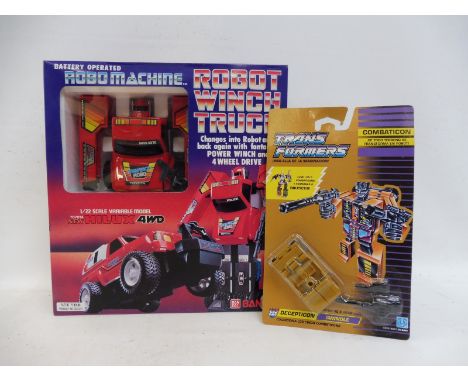 A boxed Robomachine Robot Winch Truck by Bandai and a Transformers 'Combaticon' carded vehicle.