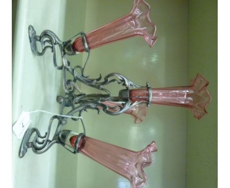 A modern Art Nouveau inspired, cast, silvered metal framed epergne with four cranberry coloured glass trumpets  16''h      OS