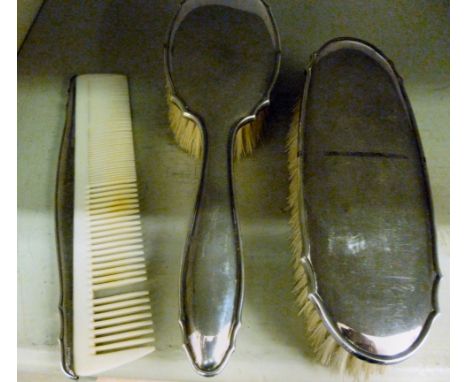 A silver coloured metal mounted hair brush, a matching clothes brush and comb  stamped 800      OS2