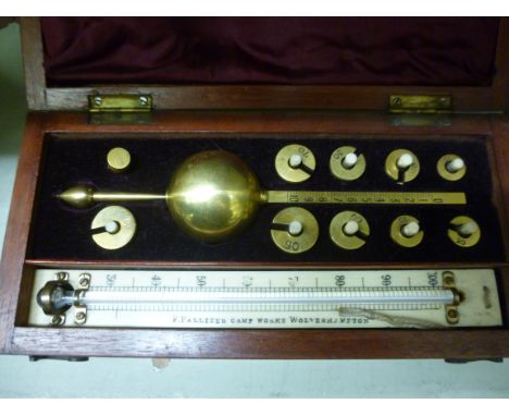 An early 20thC lacquered brass Sikes Hydrometer, in a fitted, maroon fabric lined mahogany case, the engraved ivory backplate