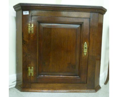 A George III oak corner cabinet, having a panelled door, enclosing a shelf, on a plinth  25''h  28''w       SR