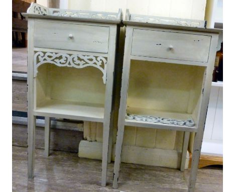 A pair of modern 'antique' finished washed, cream coloured bedside cabinets, each having a short drawer, over an open shelf, 