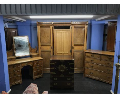 A Victorian aesthetic movement bedroom suite comprising; a triple door wardrobe, chest of drawers and dressing chest by R. Ga