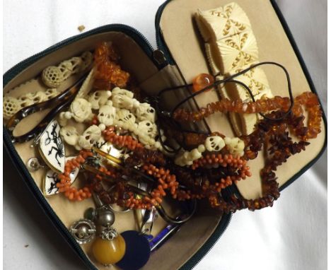 A green leatherette box containing two Amber Chip Necklaces, Coral Necklace, Bone Necklace and Bracelet and other oddments  