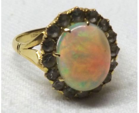 An Oriental yellow metal Central Oval Opal and white stone surround Cluster Ring  