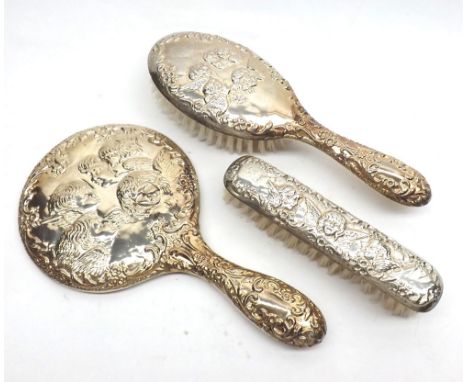 An Elizabeth II Three Piece Silver-Backed Dressing Table Set, each item embossed with angelic choir detail, comprising hand m