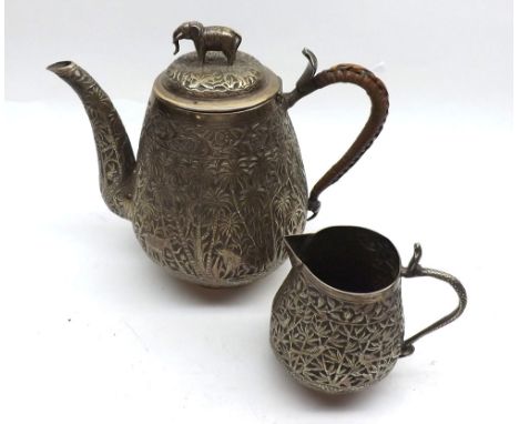 A late 19th/early 20th Century Indian white metal Teapot of tapering baluster form, highly engraved with a jungle scene, elep