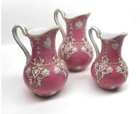 Graduated set of three Victorian Jugs decorated with stylised foliage and gilt highlights on a pink background, largest 8 1/2