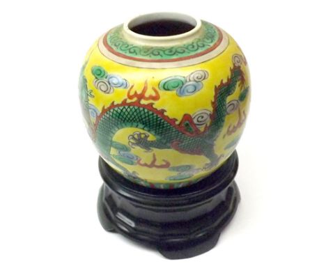 Oriental Ginger Jar decorated in famille vert with dragons on a lemon ground (lid missing) together with a black ceramic stan