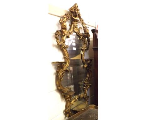A 20th Century simulated gilt wood Italianate style Wall Mirror, the shaped frame decorated with floral swags, cherub heads a