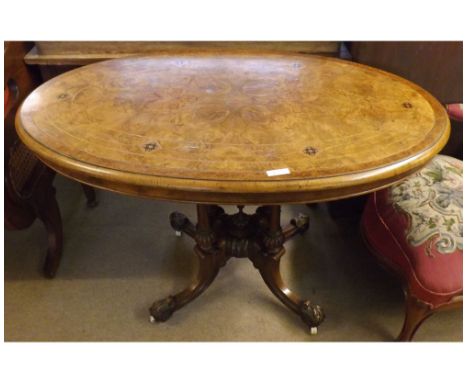 Small Victorian Burr Walnut veneered oval Loo Table, raised on a quatre pedestal base with scrolled feet and Brass and cerami