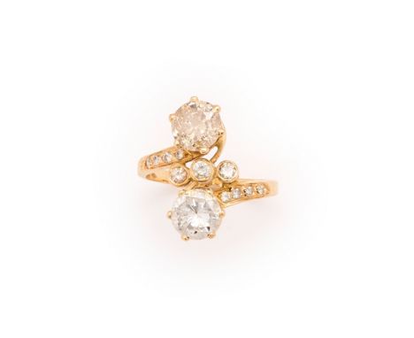 DIAMOND RING crossover design claw set with two brilliant-cut diamonds, with diamond set detail to the centre and shoulders, 