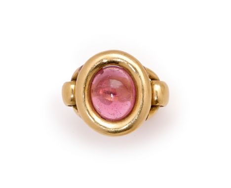 PINK TOURMALINE RING centring on an oval pink tourmaline cabochon, inset to a bezel of buckle design, French assay and maker'