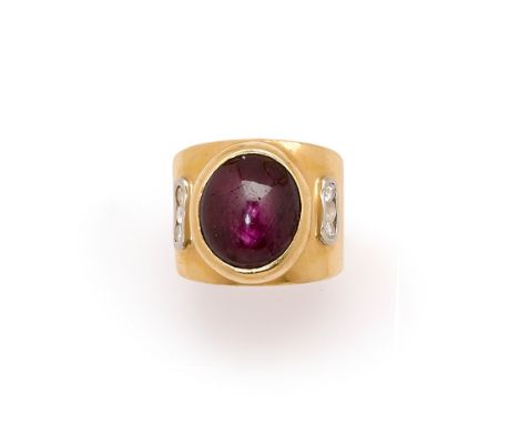 A RUBY AND DIAMOND RING collet set with an oval cabochon ruby, the shoulders with diamond accents, stamped 750, ring size K.G