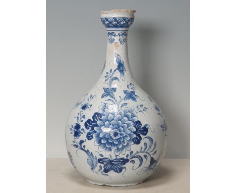 A blue and white Delft Bottle Shaped Vase with all over Floral designs (Rim Chipped) 9.5" High.  Lots of chips to the top rim