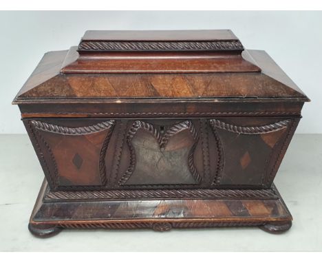 A 19th Century rosewood and mahogany Sarcophagus Tea Caddy, with applied carved panels, pair of ring carry handles, with two 